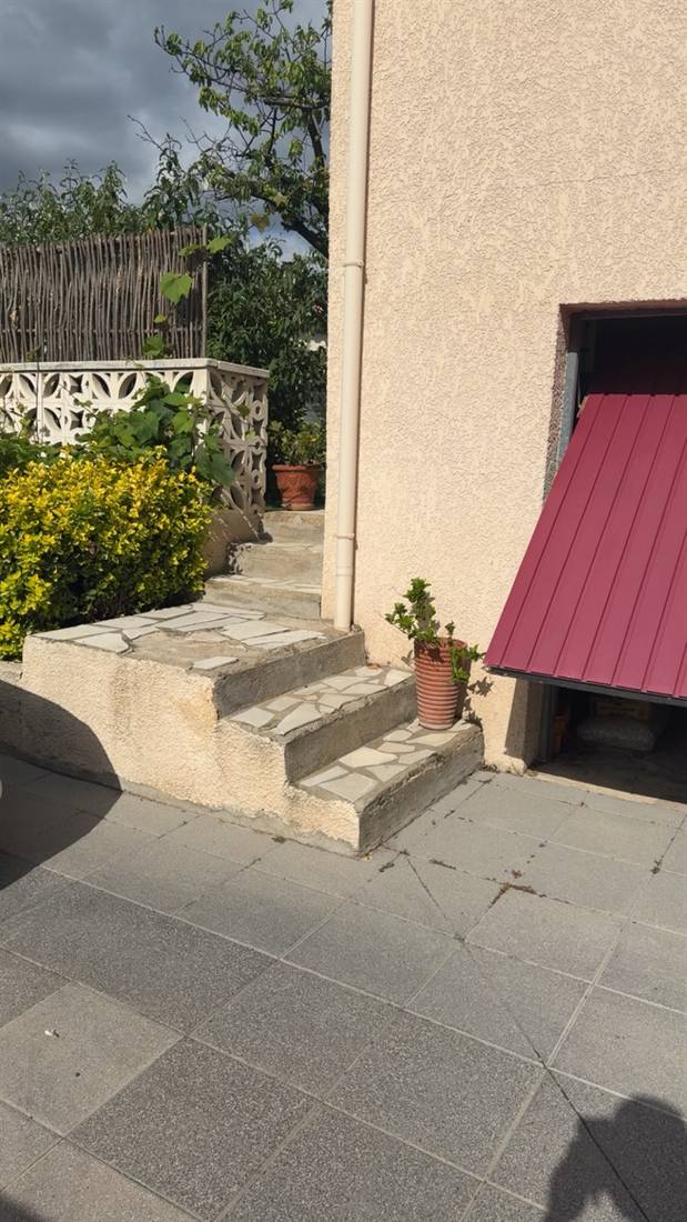 Escalier extérieur en béton habillé de dallage pierre menant à la terrasse, chantier à Béziers