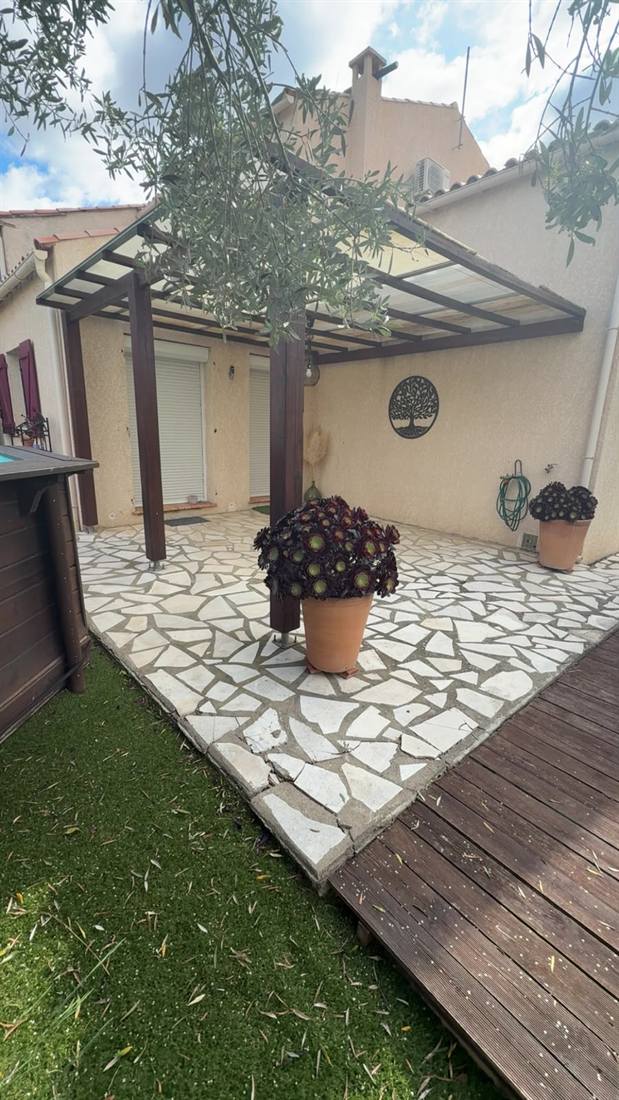 Terrasse en dallage pierre naturelle opus incertum sous pergola réalisée par un maçon à Béziers